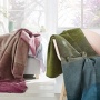 Pluche dekens in de kleuren blauw/groen of roze/bessen verkrijgbaar