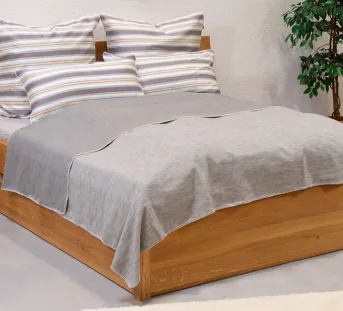 Omkeerbare sprei over een bed in de kleur grijs in de afmeting 220x250 cm