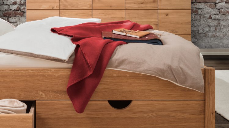 Gezellige katoenen pluche deken op bed - hier in het rood